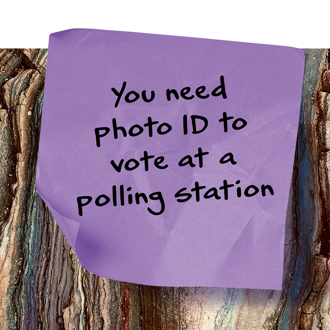 A post it sticker saying 'You need photo ID to vote at a polling station'
