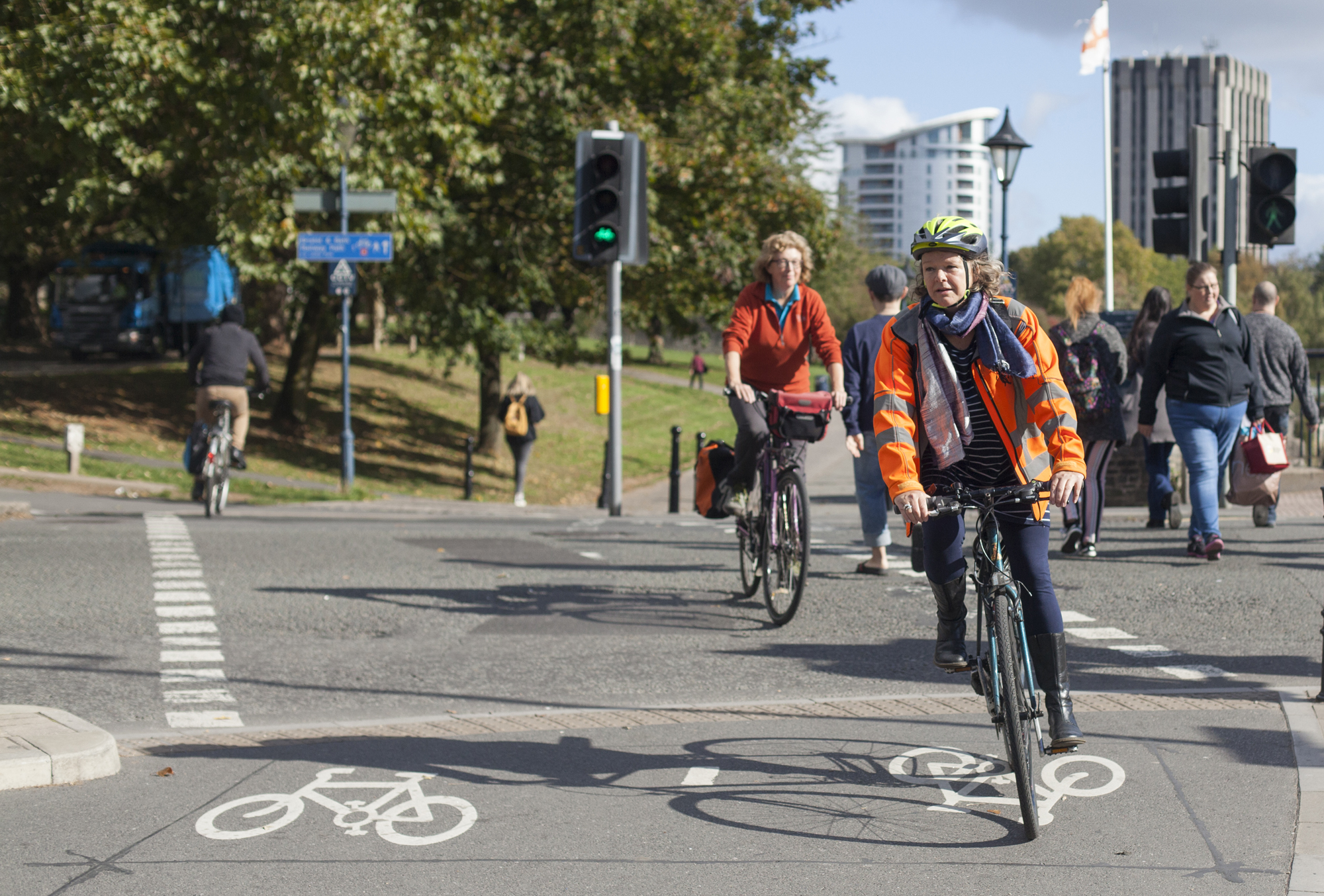 Two people in high-vis riding along a bike lane by Castle Park in Bristol.