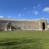 View of the front of Bristol's City Hall, a large grand brick building, across the green lawn of College Green
