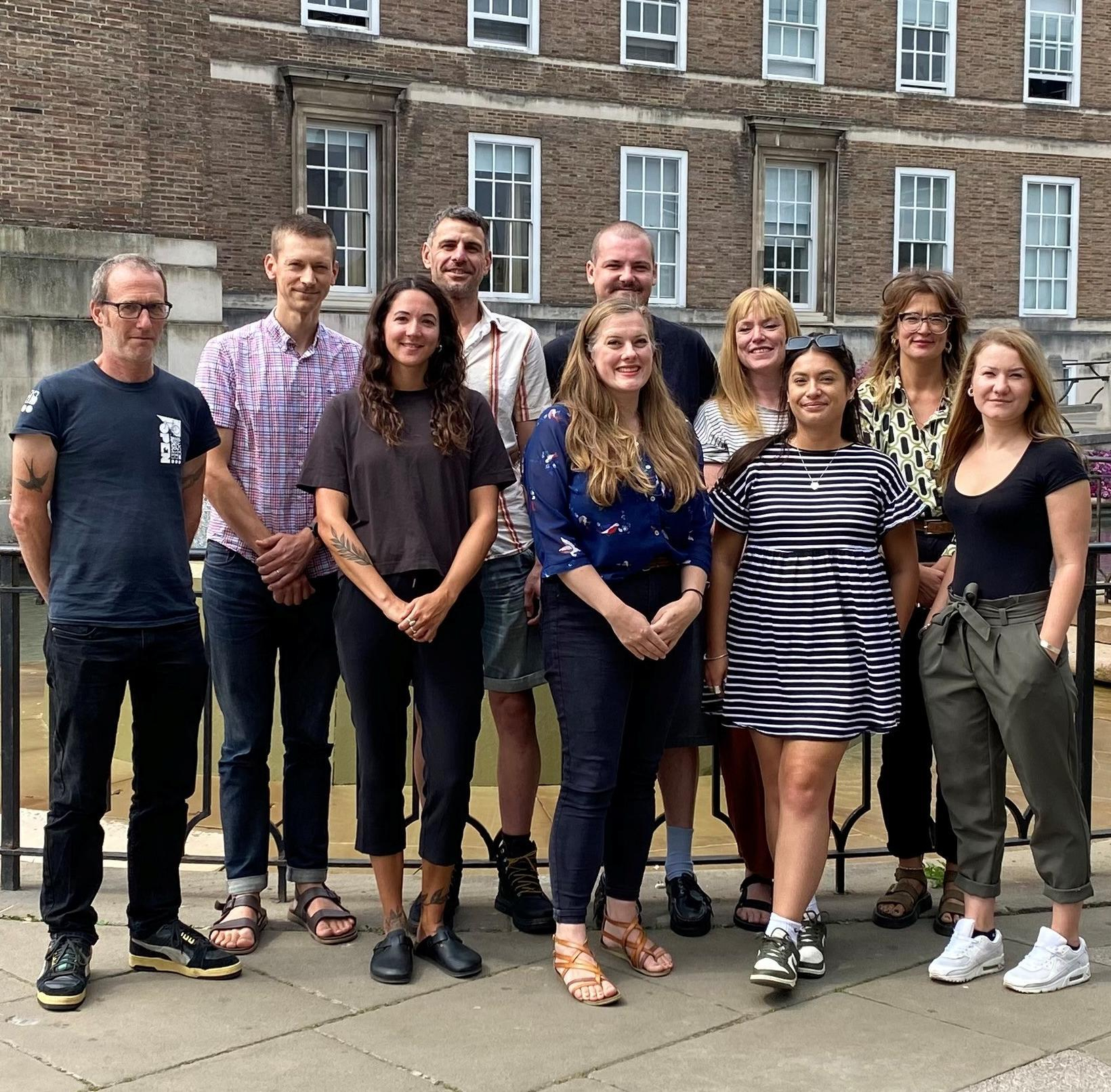 Ten members of Bristol City Council's Homeless Move On Team standing together posing for a photograph
