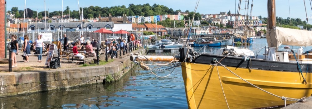 Yellow boat on the water, people in the background
