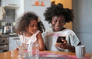 Woman and young girl sitting in the kitchen for breakfast