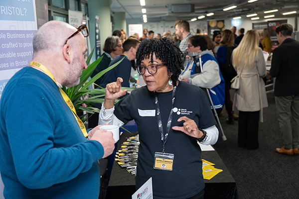 A man listens to woman explaining about the Black Business Network at the Better Bristol business convention