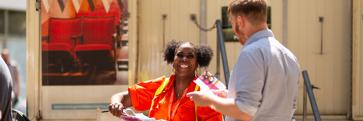 A woman talks to a man about a mobile cinema coach parked in Bristol's Broadmead shopping area