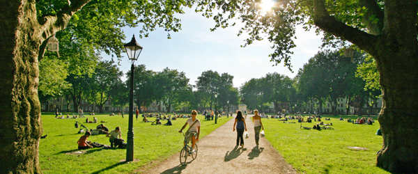 queen's square on a sunny day with many people sitting on the grass