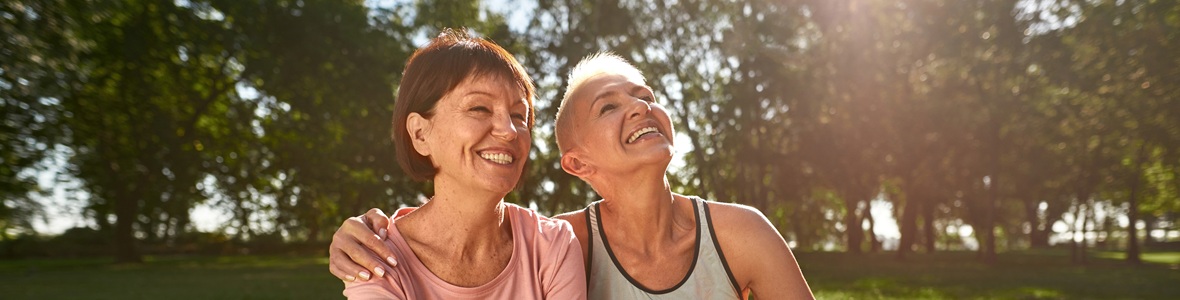 Two ladies smiling in a park on a sunny day