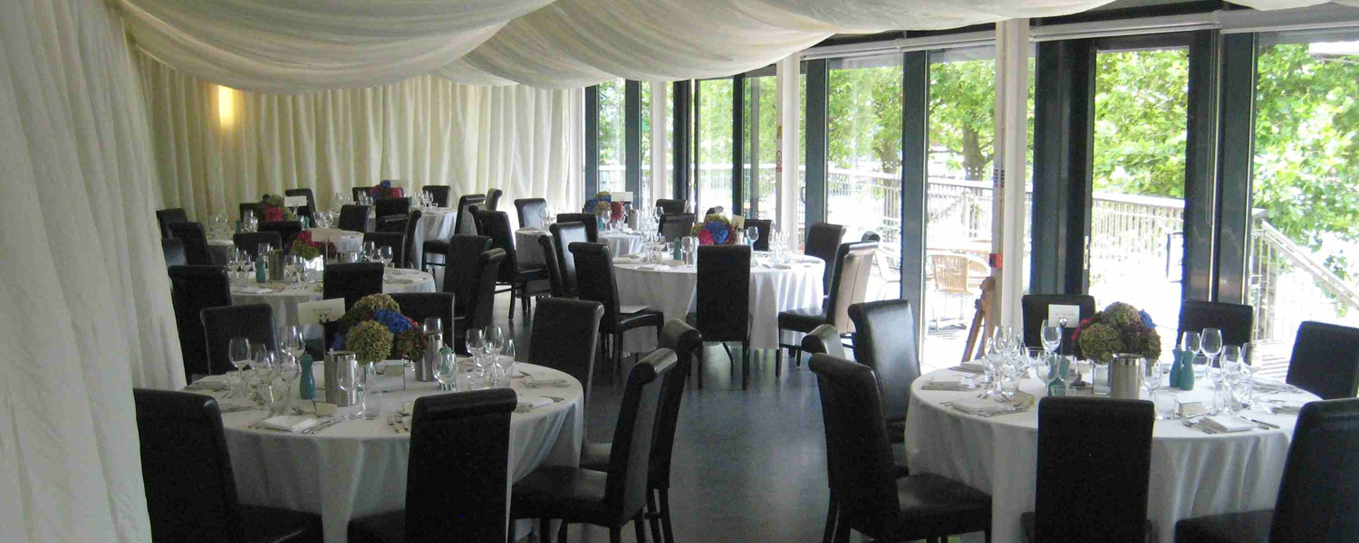 A function room of the Harbourside pavilion with round tables set with with fabric tablecloths