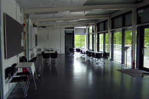 A large room with floor to ceiling windows opening onto a balcony