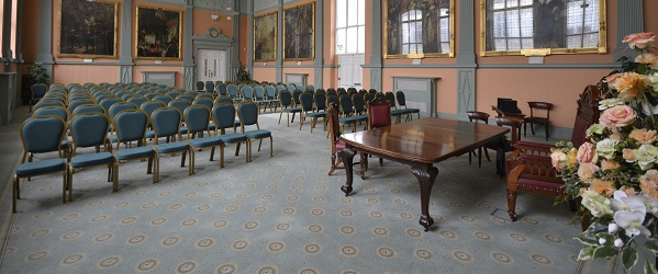 a heritage room with paintings on the walls and rows of chairs